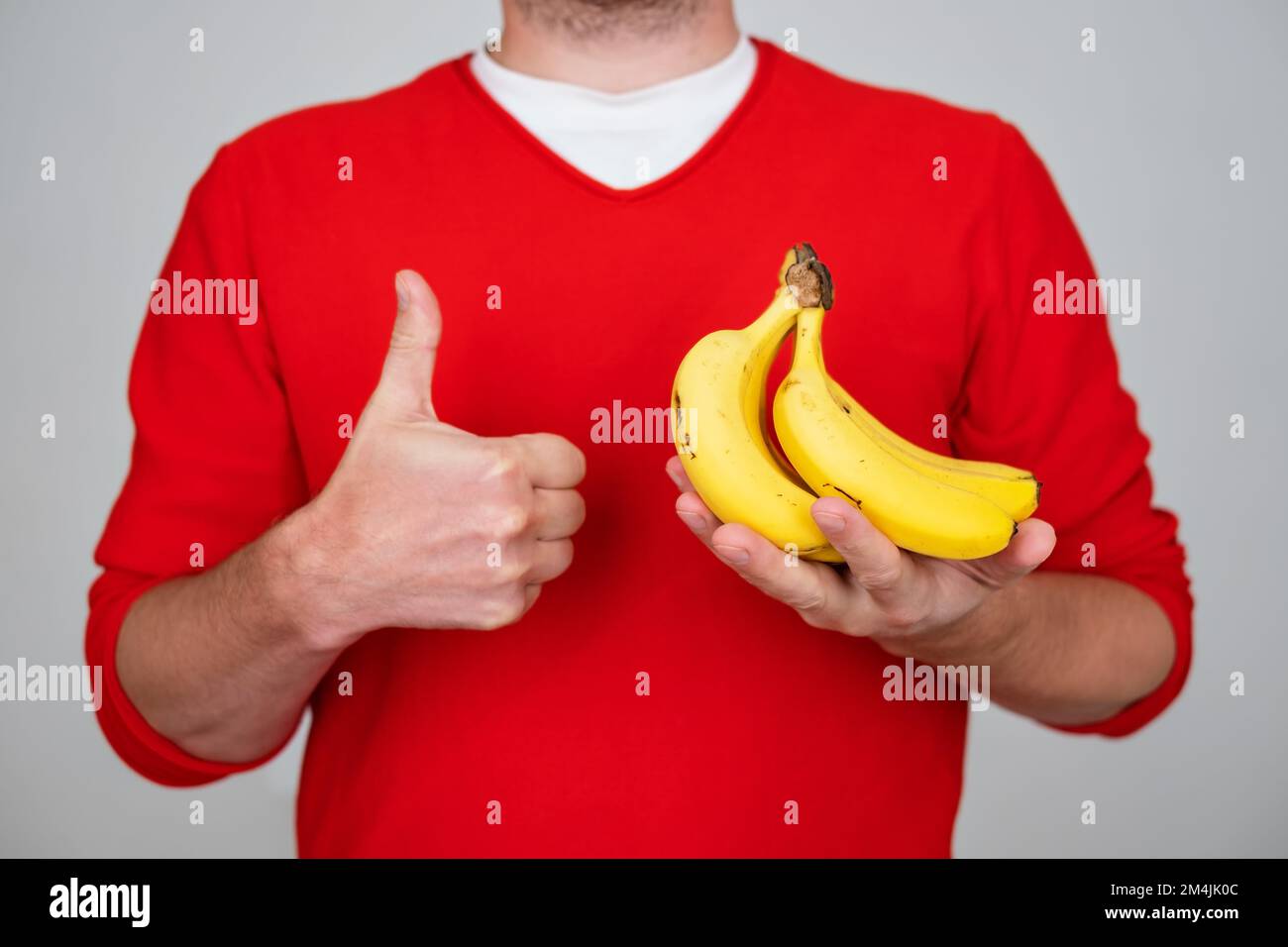 Mann mit Banane, Daumen hoch, ausgezeichnet, und Genehmigungszeichen Stockfoto