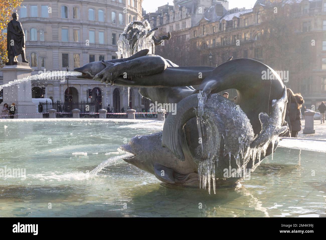 Der Brunnen am Trafalgar Square bleibt bis zum Morgen gefroren. Die Leute haben Spaß mit Eisstücken auf dem Brunnen. Aufnahme am 16. Dezember 2022. ©B Stockfoto