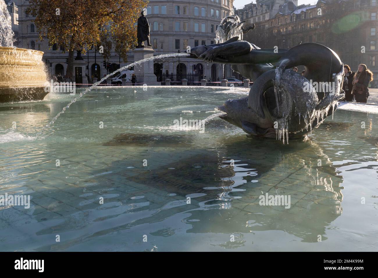 Der Brunnen am Trafalgar Square bleibt bis zum Morgen gefroren. Die Leute haben Spaß mit Eisstücken auf dem Brunnen. Aufnahme am 16. Dezember 2022. ©B Stockfoto