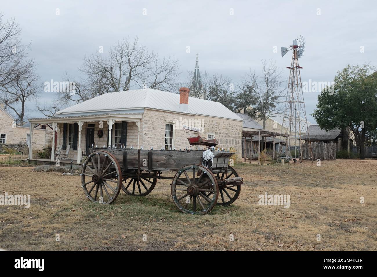 Eine Nahaufnahme eines alten Drachenwagens gegen ein Haus in Fredericksburg, Texas, USA Stockfoto