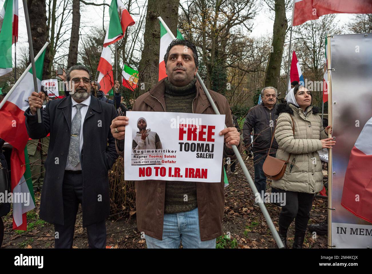 Den Haag, Niederlande, 21/12/2022, Eine Gruppe männlicher und weiblicher Demonstranten, während der heutigen Demonstration in Den Haag, bei der das iranische Regime angeprangert wird; mit Flaggen und einem Poster eines Opfers im Iran. Eine nicht allzu große, aber sehr lautstarke Gruppe iranischer Anhänger hat heute Nachmittag einen lauten Protest inszeniert und das niederländische Repräsentantenhaus aufgefordert, die iranische Botschaft in den Niederlanden zu schließen und ihre Diplomaten auszuweisen. Vor einigen Wochen brachen im Iran Massendemonstrationen aus, nachdem die Sicherheitskräfte hart gegen Demonstranten vorgegangen waren. Von den Verhaftungen waren zwei für den plötzlichen Tod des 22-jährigen Mahs verantwortlich Stockfoto