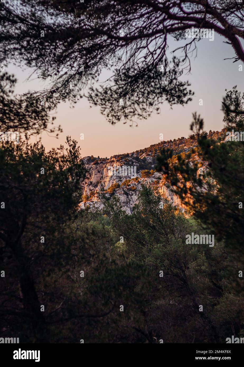 Ein vertikaler Blick auf den Sonnenuntergang über dem Massiv der Calanques, bedeckt mit üppigem Grün Stockfoto
