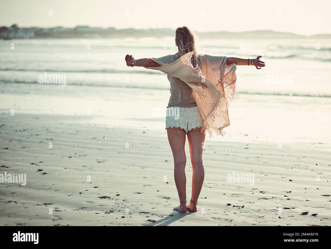 Es ist das Meer, das ihr das Gefühl gibt, so frei zu sein. Rückansicht einer Frau, die einen Tag am Strand verbrachte. Stockfoto