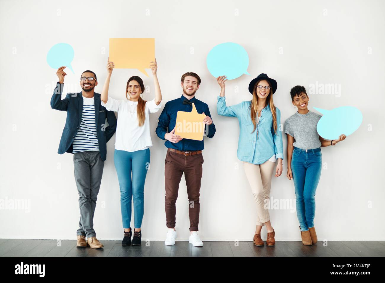 Unsere Meinungen sind wichtig. Eine vielfältige Gruppe von kreativen Mitarbeitern hält Sprechblasen in sich. Stockfoto