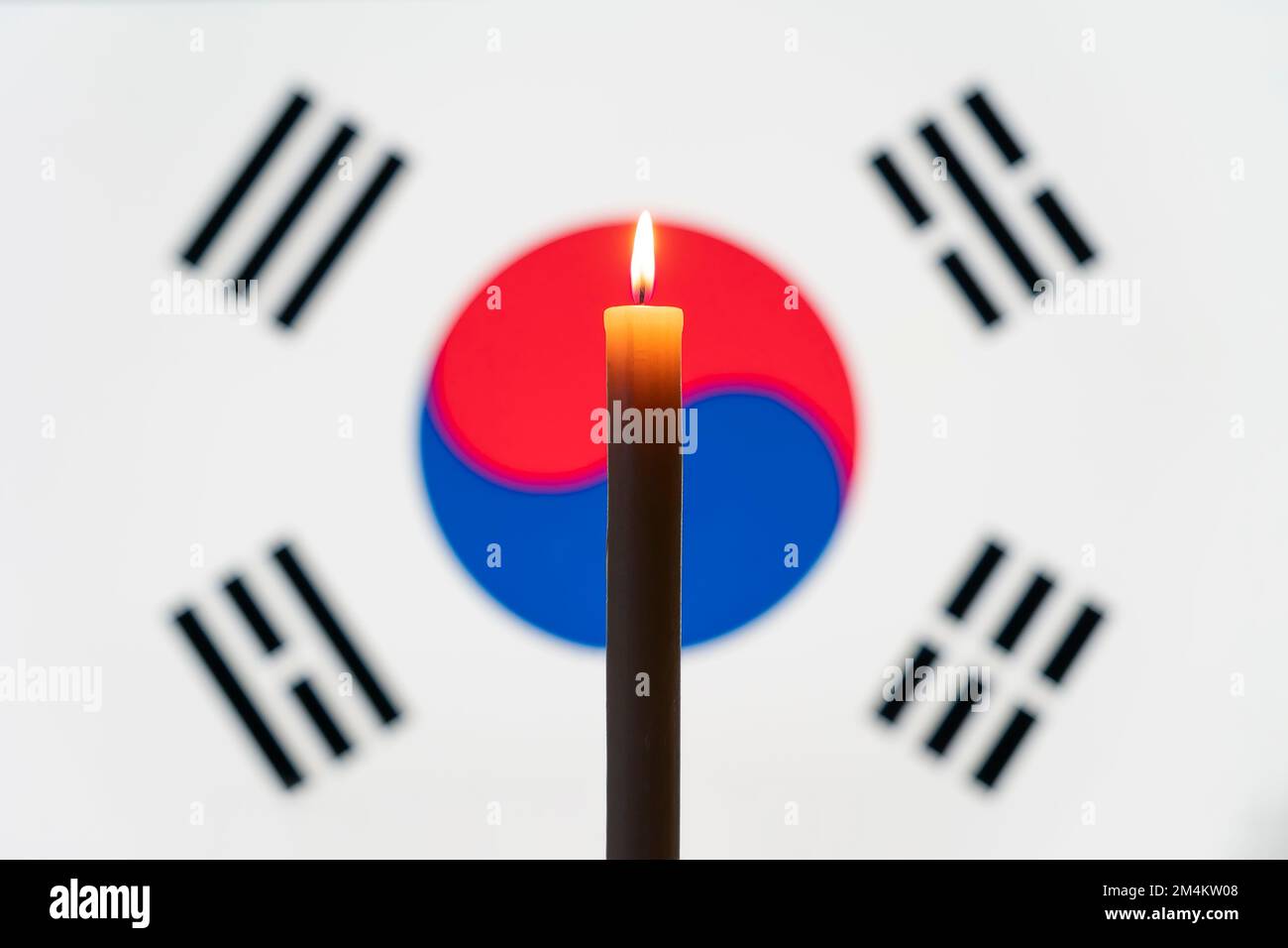Trauer auf dem Land. Eine brennende Kerze auf dem Hintergrund der südkoreanischen Flagge. Opfer von Katastrophen oder Kriegsbegriff. gedenktag, Erinnerung da Stockfoto