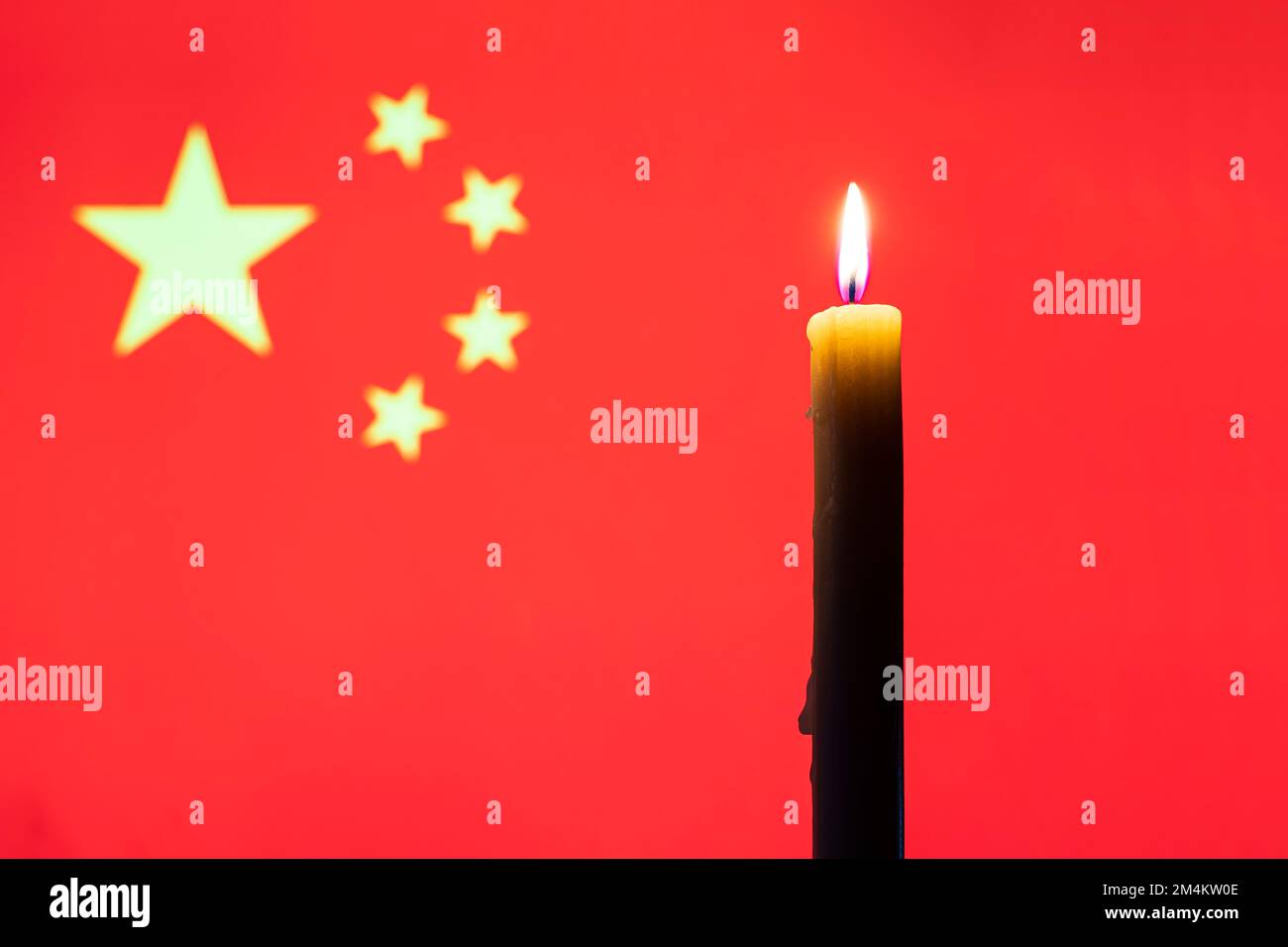Trauer auf dem Land. Eine brennende Kerze auf dem Hintergrund der chinesischen Flagge. Opfer von Katastrophen oder Kriegsbegriff. gedenktag, Gedenktag. Nat Stockfoto