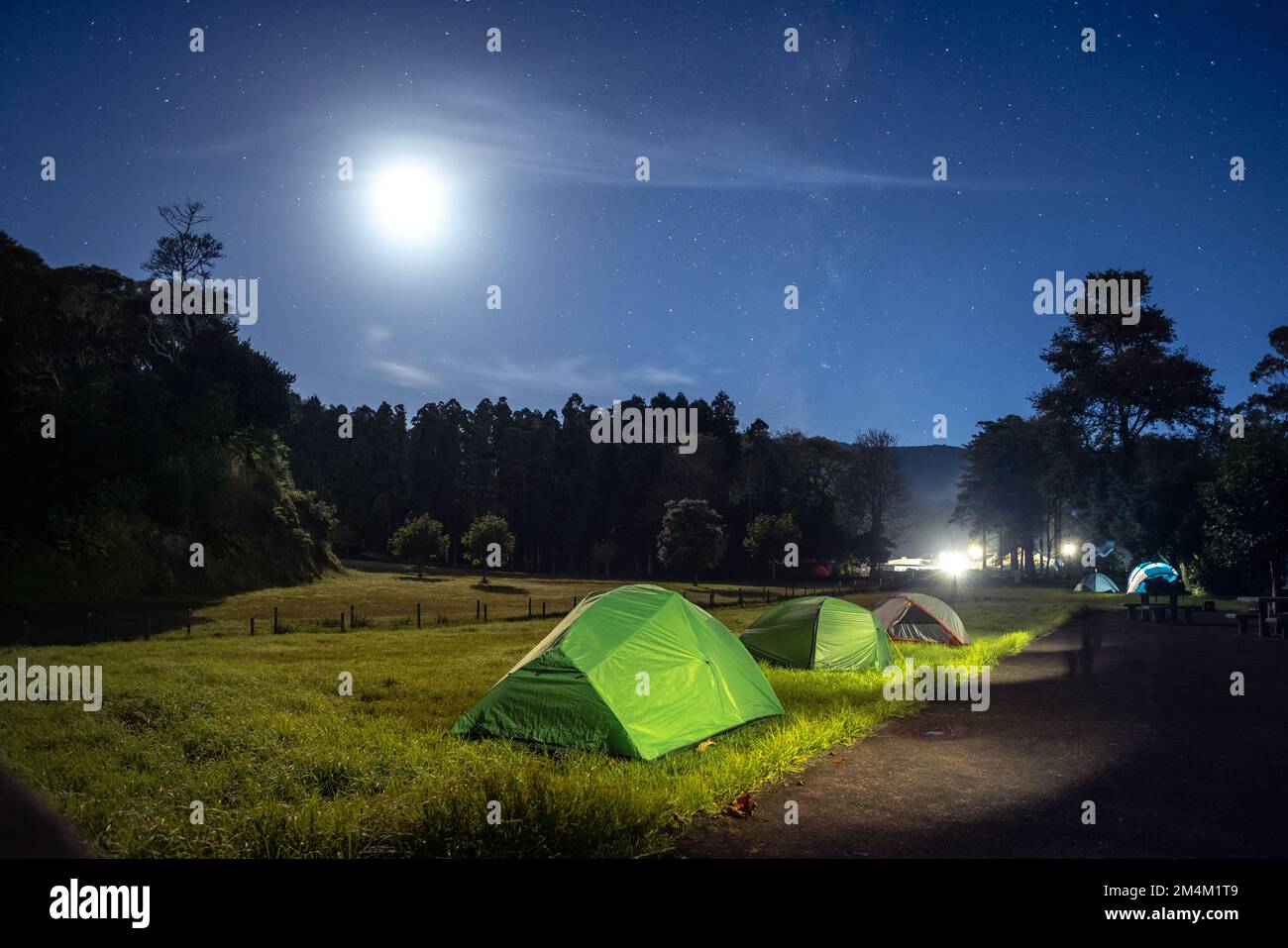 Camping auf einem Campingplatz unter einem Sternenhimmel bei Mond Stockfoto