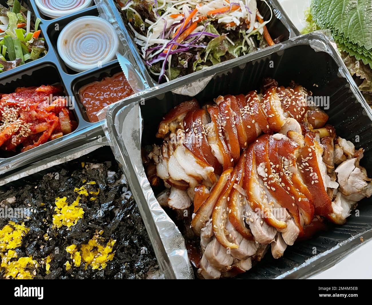Ein Set koreanischer Jokbal-Gerichte (Schweinefleisch) mit Jumeokbap (Reisball), Makguksu (Buchweizennudeln) und Rettichkimchi Stockfoto