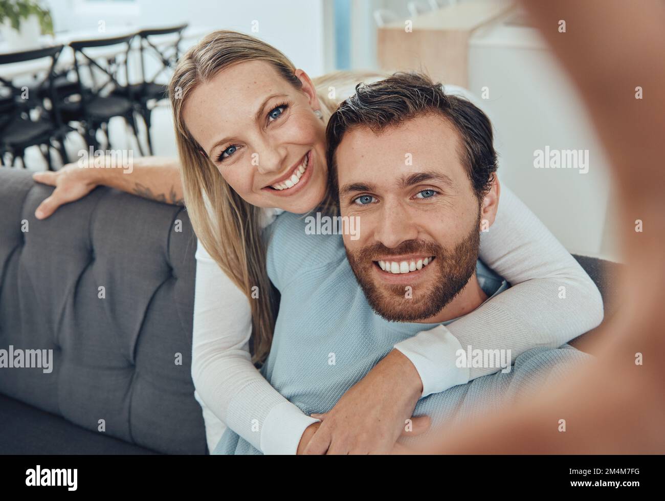 Liebe, Selfie und Paar auf dem Sofa, Lächeln und Verbundenheit für Beziehung, Wochenendausflug und Romantik. Porträt, Mann und Frau lieben, romantisch und umarmen Stockfoto