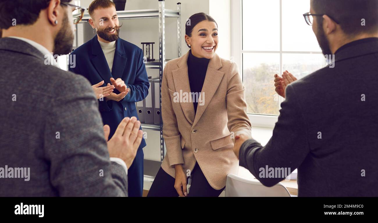 Kollegen im Büro, die sich um eine Einigung bemühen, umgeben von einem ganzen Business-Team. Stockfoto