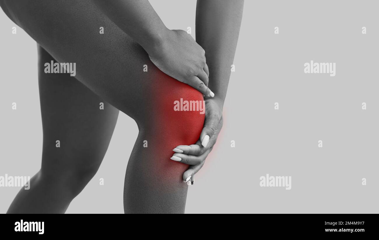 Eine Frau, die an Arthritis leidet, fühlt Schmerzen und berührt ihr Knie, Bannerhintergrund Stockfoto