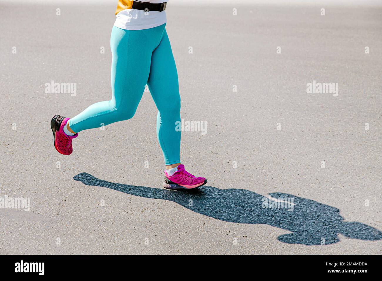 Läuferin in türkisfarbenen Leggings beim Laufrennen Stockfoto