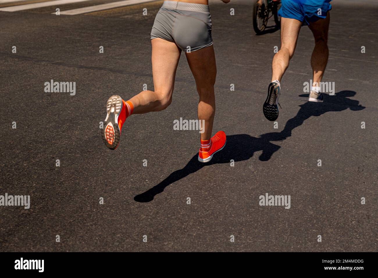 Frauen und Männer Rennen auf dunklem Asphalt Stockfoto