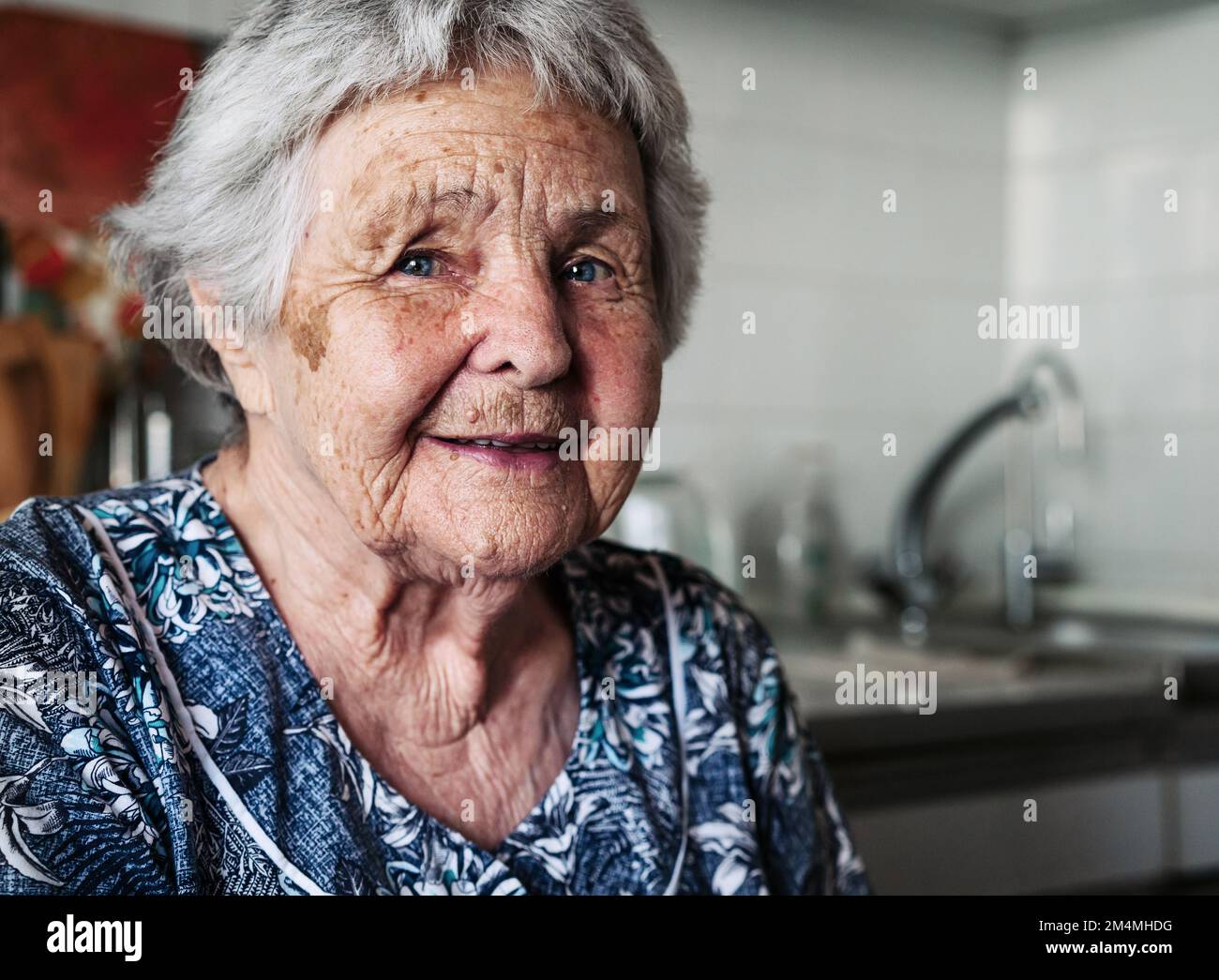 Porträt einer zweiundneunzig Jahre alten weissen Weißen, Seniorin, die zu Hause in die Kamera schaut und lächelt. Stockfoto