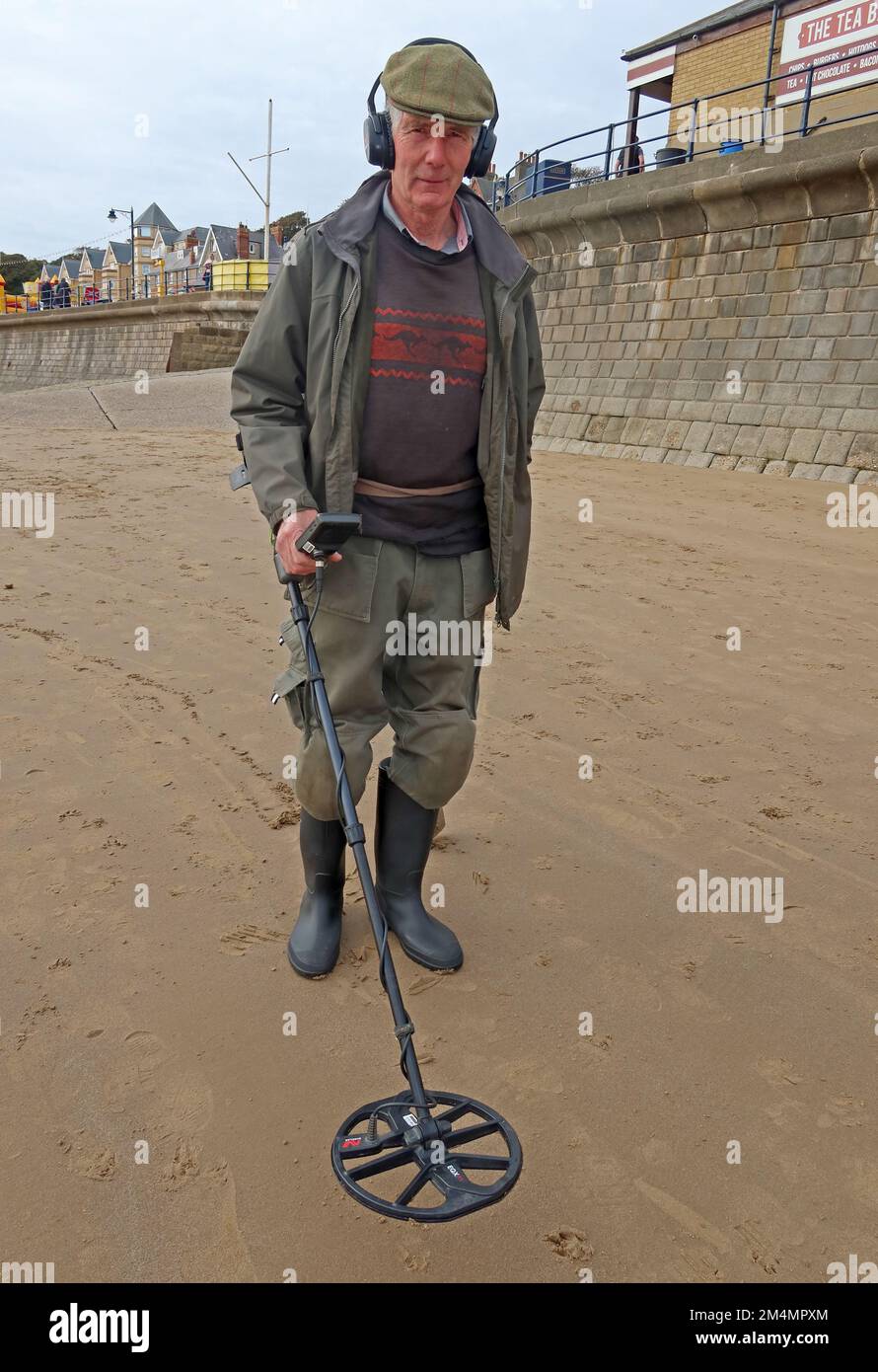 Ein Mann, der einen Metalldetektor benutzt, am Strand, in der Nähe von Filey, North Yorkshire, England, UK, YO14 9LA Stockfoto