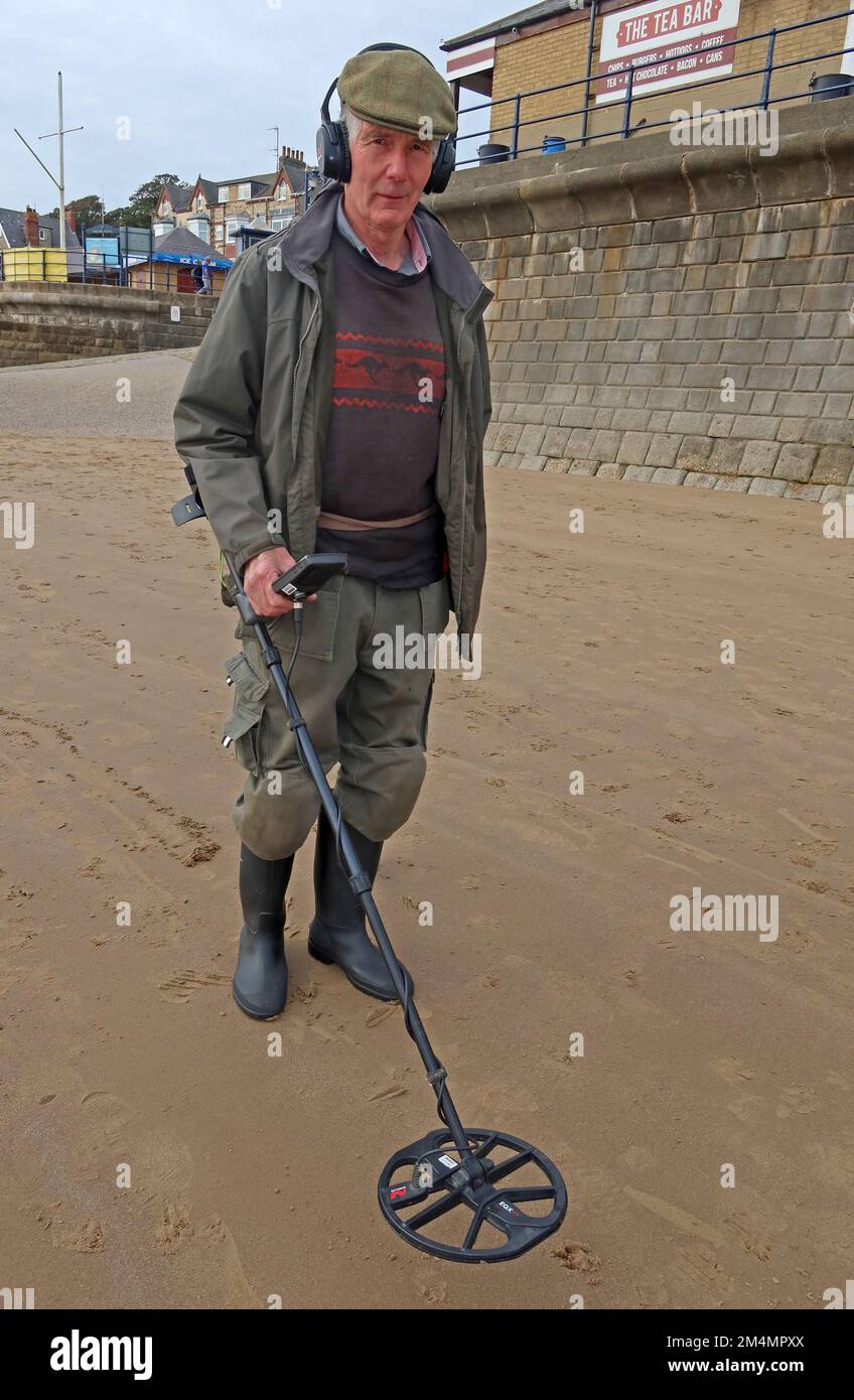 Ein Mann, der einen Metalldetektor benutzt, am Strand, in der Nähe von Filey, North Yorkshire, England, UK, YO14 9LA Stockfoto