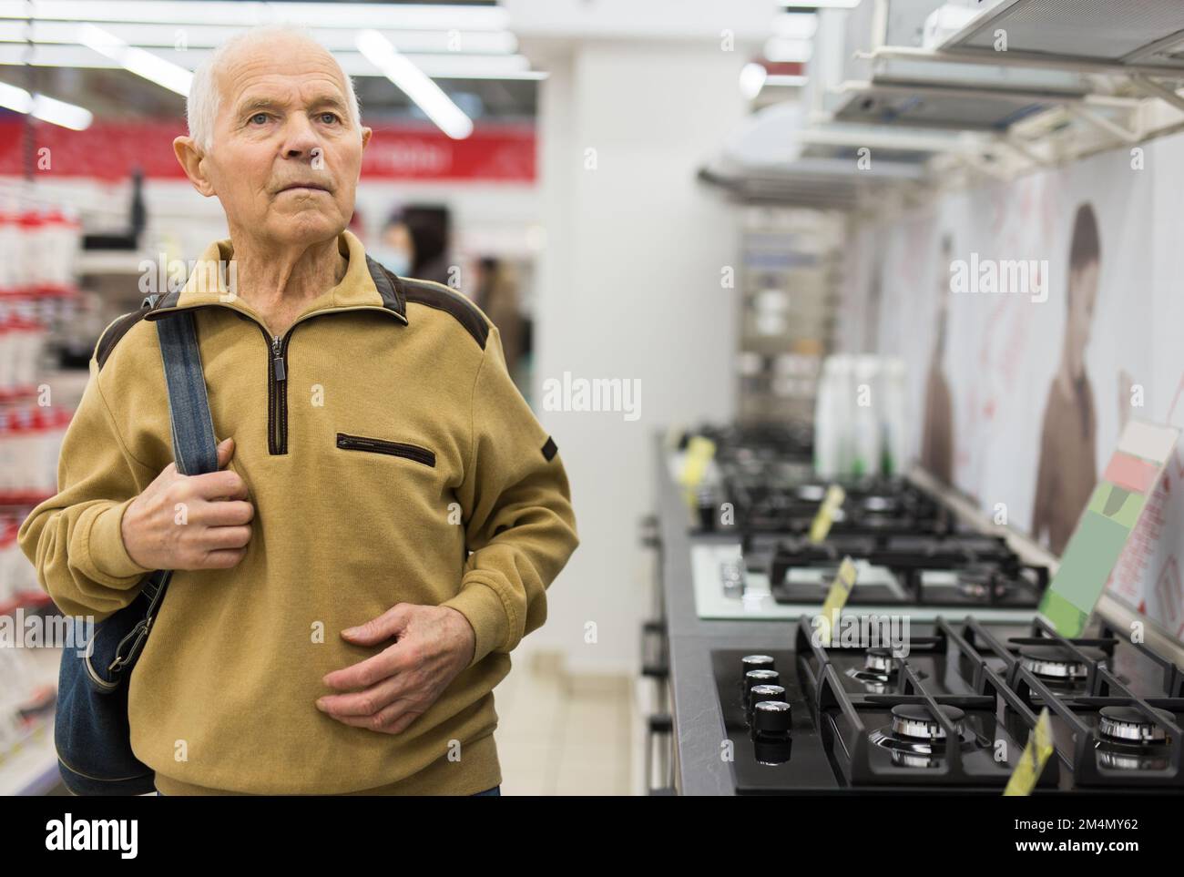 senor Mann Rentner Kauf Küchenherd im Ausstellungsraum des Elektrogeräteladens Stockfoto