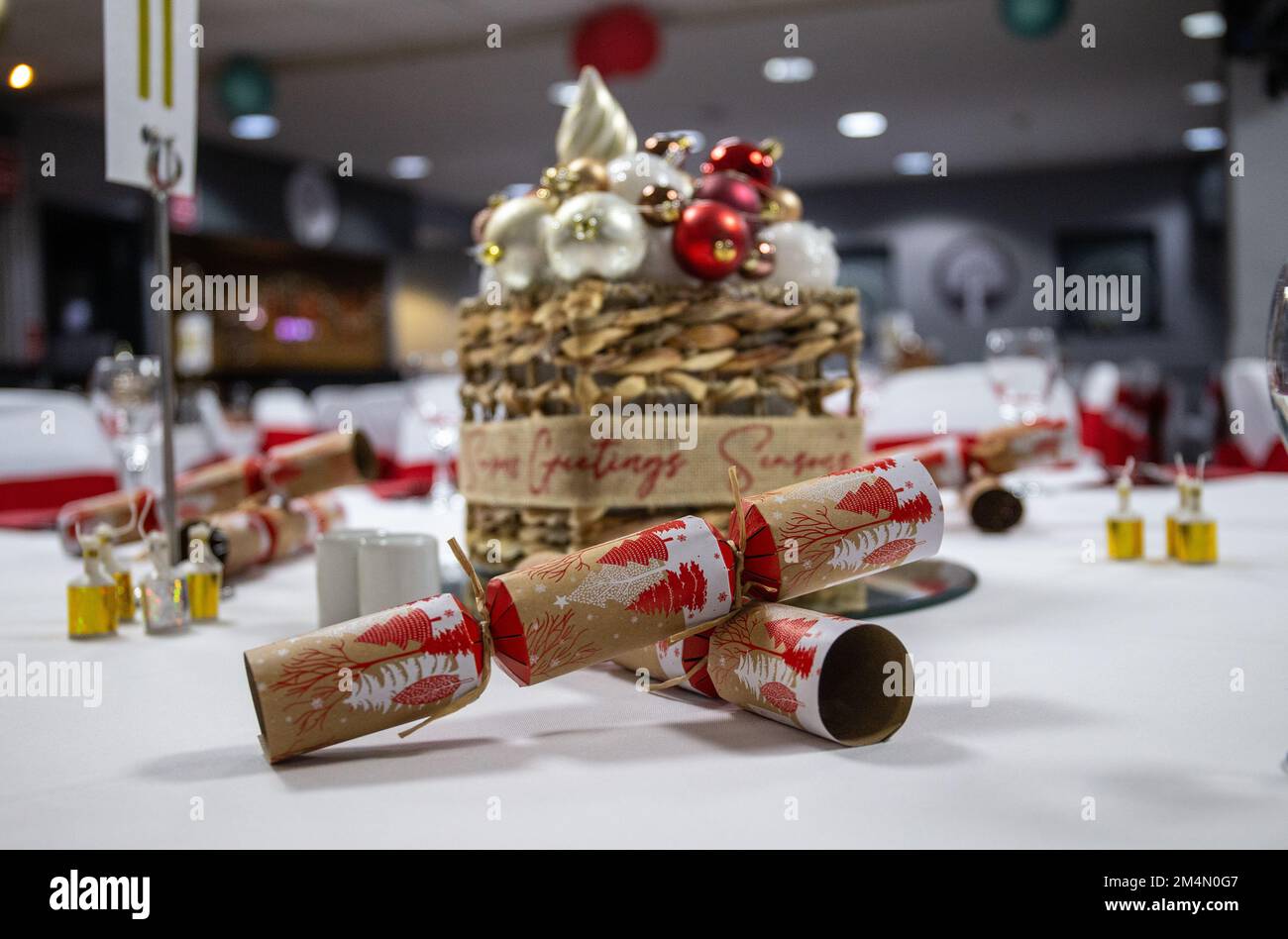 Cracker auf einem dekorierten Tisch im Veranstaltungsraum, der während der Weihnachtsfeier in Großbritannien eingerichtet ist Stockfoto