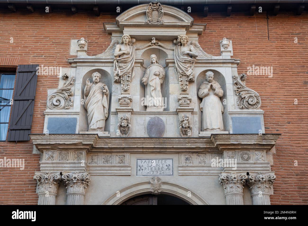 Alte Steinschnitzereien, die Jesus, den Petersdom, einen karthusischen Mönch und Engel über dem Eingangstor zur Kirche St. Pierre des Chartreux in Toulouse, Frankreich darstellen Stockfoto