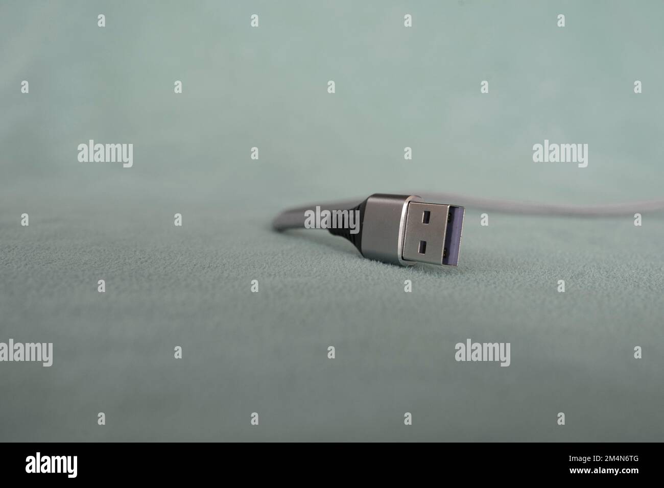 USB-Kabel auf grünem Hintergrund isoliert Stockfoto