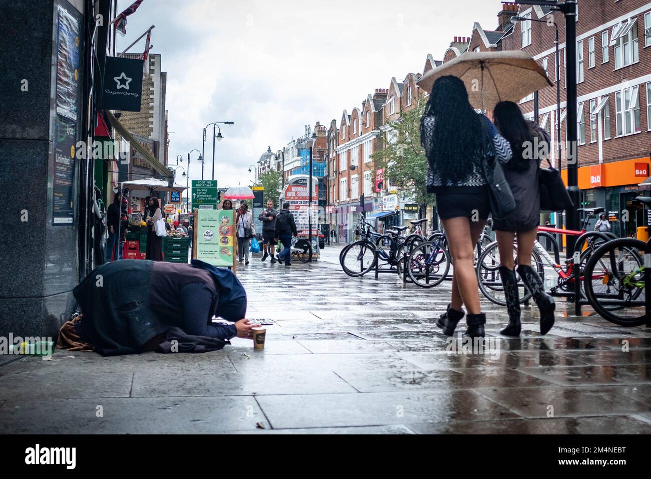 London - September 2022: Eine Frau bettelt an der Tooting High Street im Südwesten Londons Stockfoto