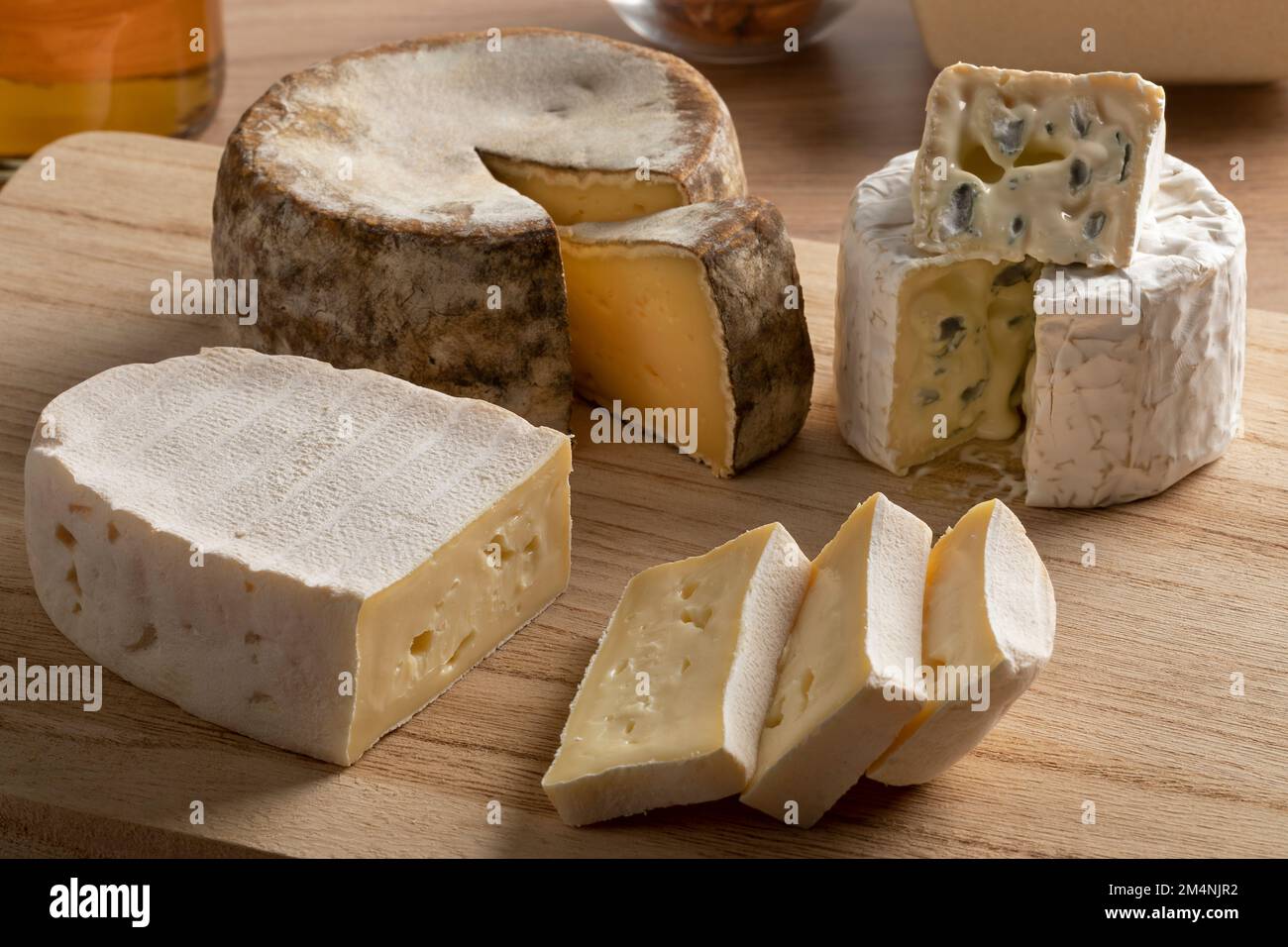 Französisches Käseboard mit einer Auswahl an Käse, Tommette de Montagne, Bresse Bleu und Le Coq de Bruyere aus nächster Nähe Stockfoto