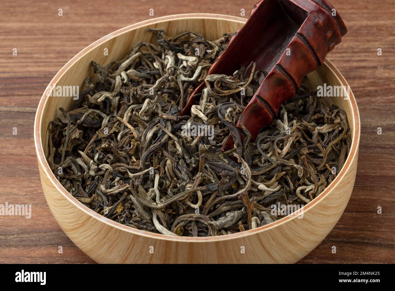 Schüssel mit getrockneten chinesischen Monkey King of Jasmin Teeblättern und einer Bambusschaufel aus nächster Nähe Stockfoto