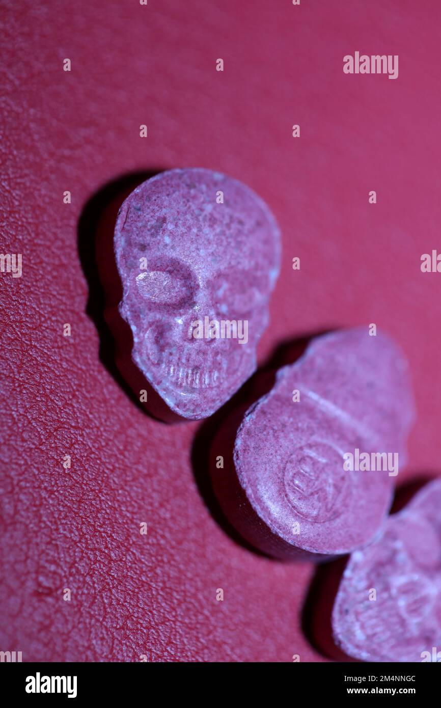 Rosa Schädel Ecstasy-Pille Nahaufnahme Hintergrund qualitativ hochwertige Drucke Purple Army-Drogen Substanz hochdosierte psychedelische Lebensweise Stockfoto