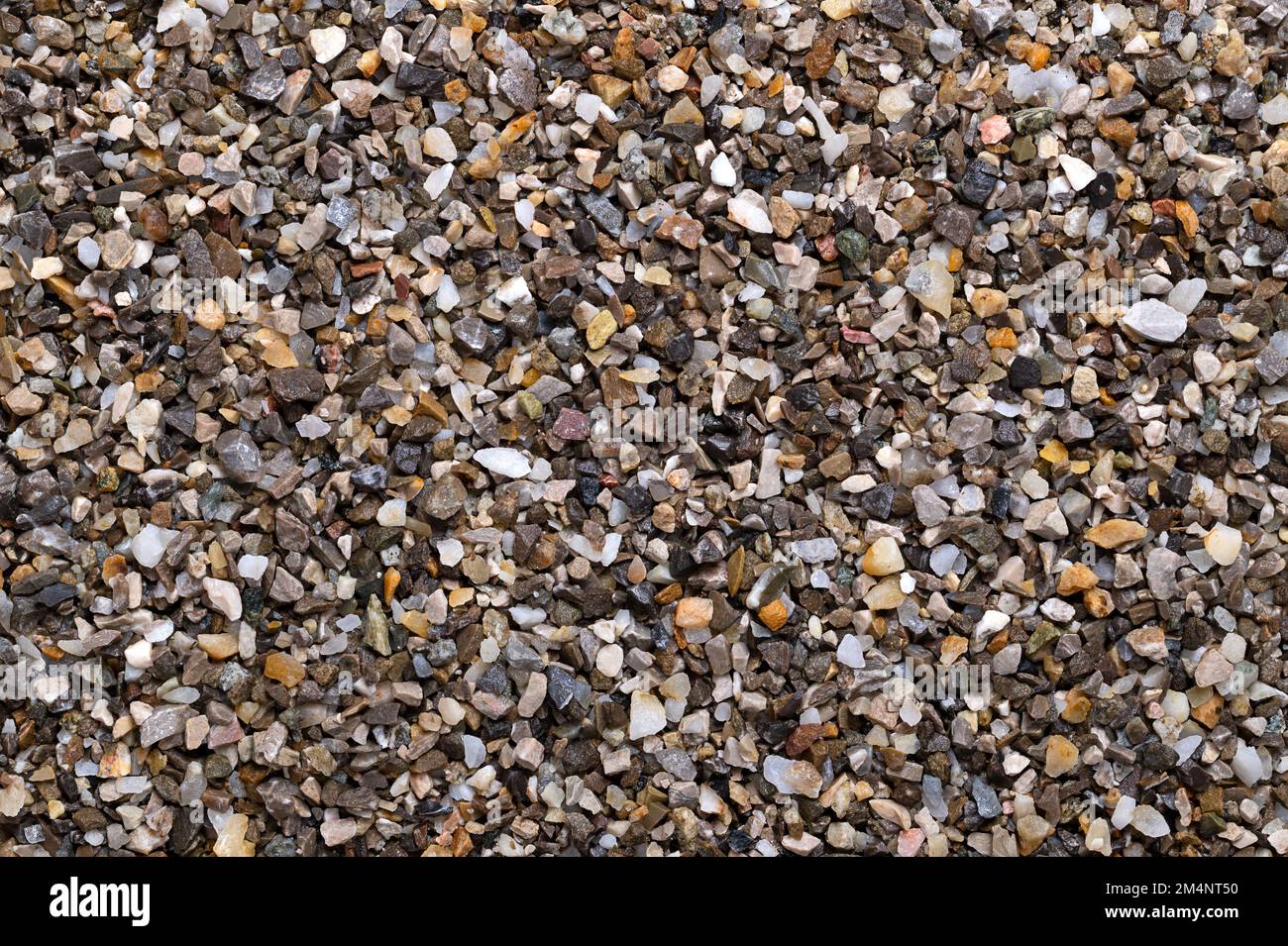 Befeuchten Sie lose Späne, zerkleinerte Steine, Straßen- und Putzkörner, Oberfläche, von oben. Kalk- und eisenfreier Quarzsand, der als Streugut verwendet wird. Stockfoto