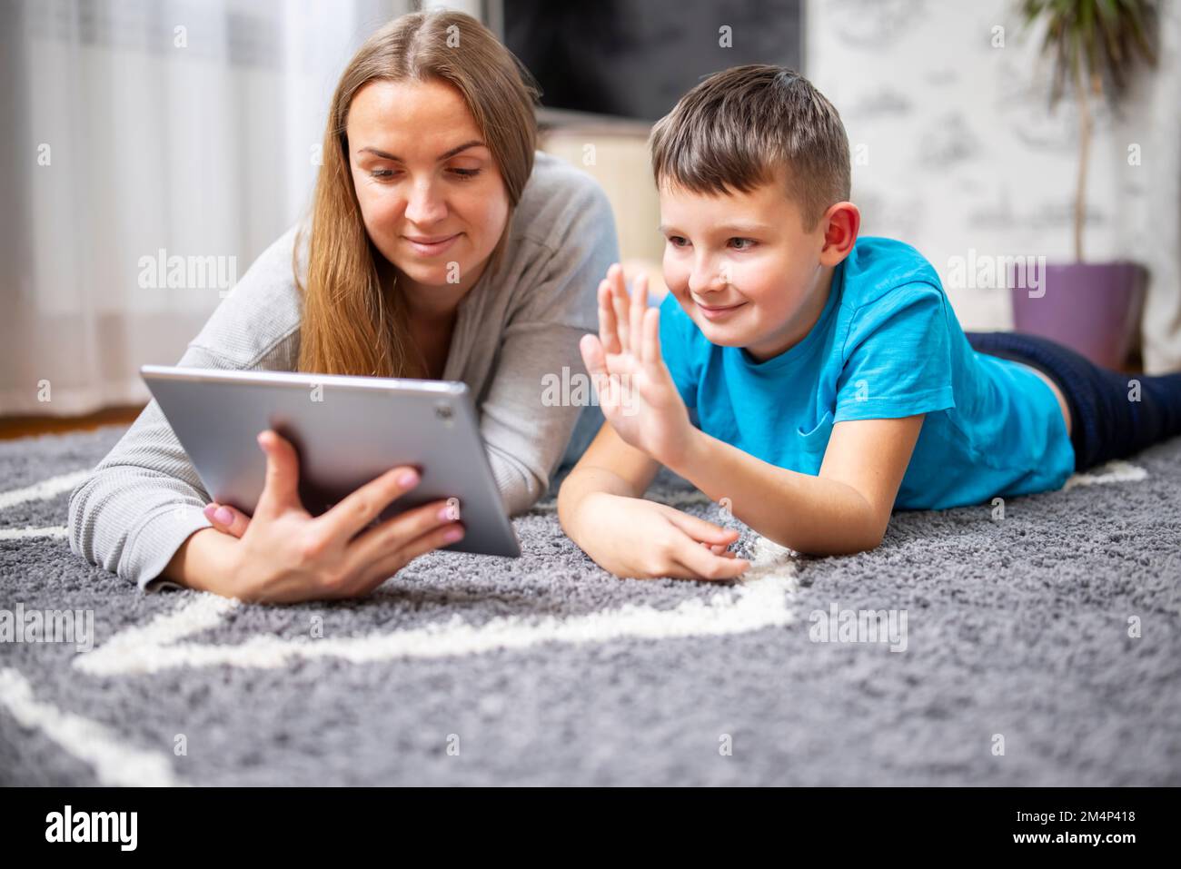 Fröhliche Mutter und Sohn, die sich online mit einem Tablet-pc eine Webkamera ansehen Stockfoto