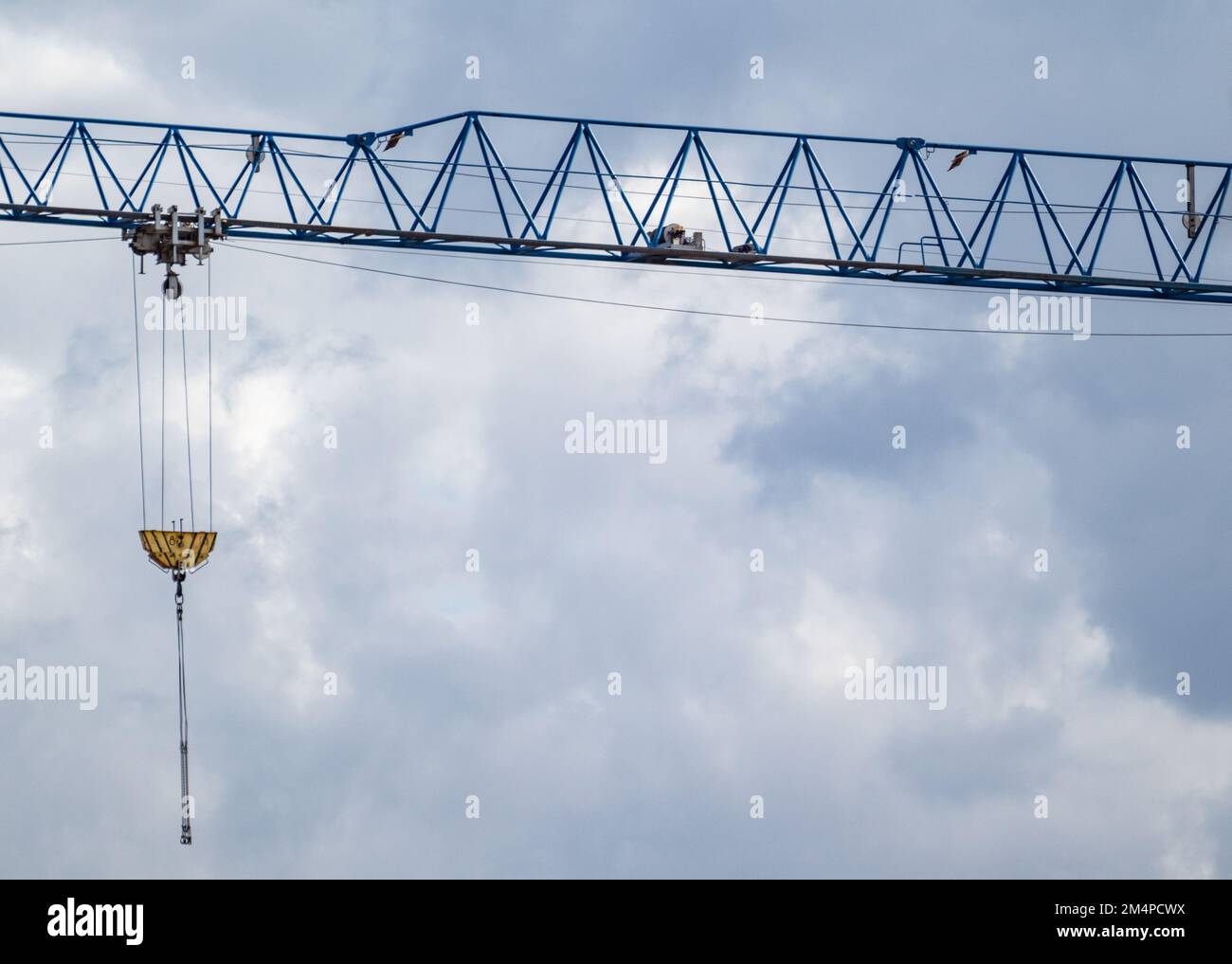Blauer, hoher Kragarm zum Heben schwerer Gewichte auf der Baustelle auf bewölktem, landschaftlich schönen Himmelshintergrund Stockfoto