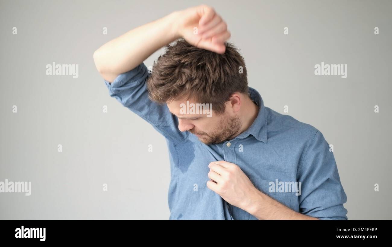 Verschwitzter Fleck auf dem Hemd wegen der Hitze, Sorgen und Divergenz. Ein Mann, der sich wegen nasser Kleidung schämt. Stockfoto