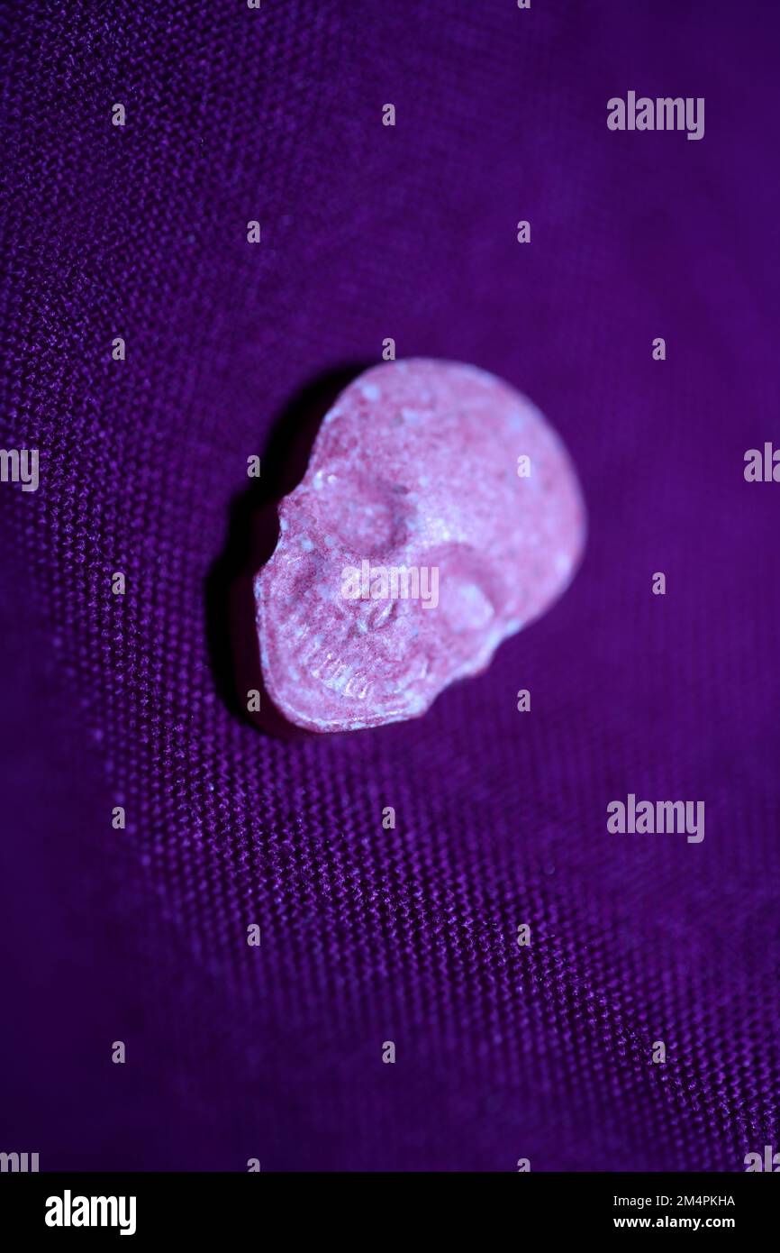 Rosa Schädel Ecstasy-Pille Nahaufnahme Hintergrund qualitativ hochwertige Drucke Purple Army-Drogen Substanz hochdosierte psychedelische Lebensweise Stockfoto