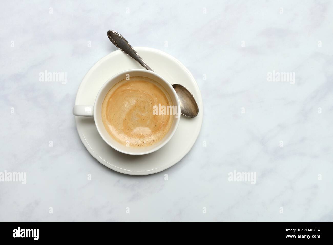 Tasse mit Kaffee und Löffel, Kaffee mit Milch, Kaffee mit Schaum Stockfoto