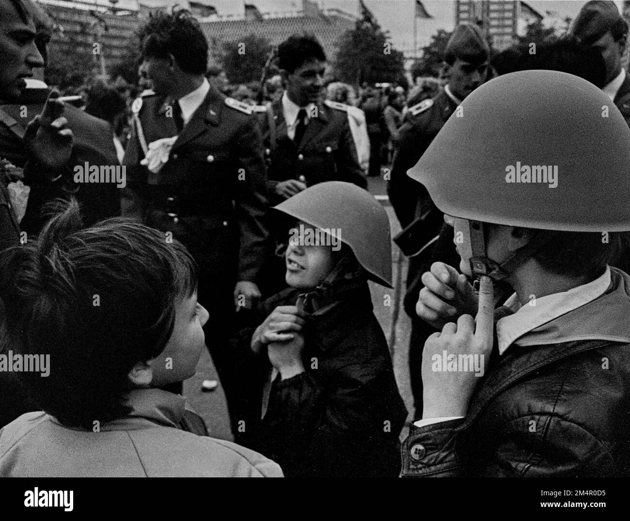 DDR, Berlin, 07. 10. 1988, NVA-Militärparade am 39. Tag der Republik, Kinder versuchen Stahlhelme am Alexanderplatz Stockfoto
