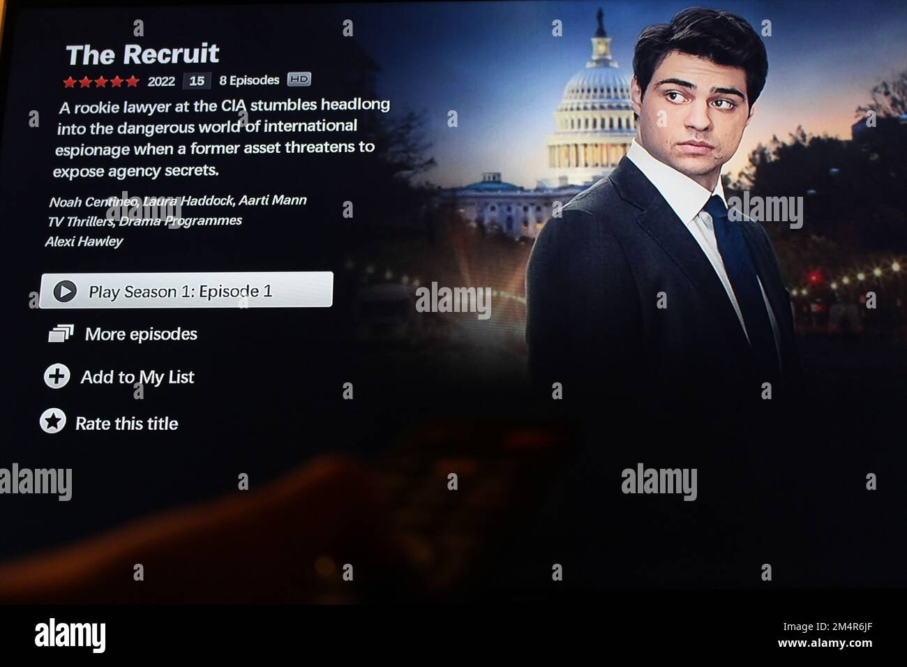 Die Netflix-App auf dem fernsehbildschirm zeigt den erfolgreichen Fernsehsender, den Rekruten, mit dem Umriss einer Hand, die eine fernbedienung vor sich hält Stockfoto