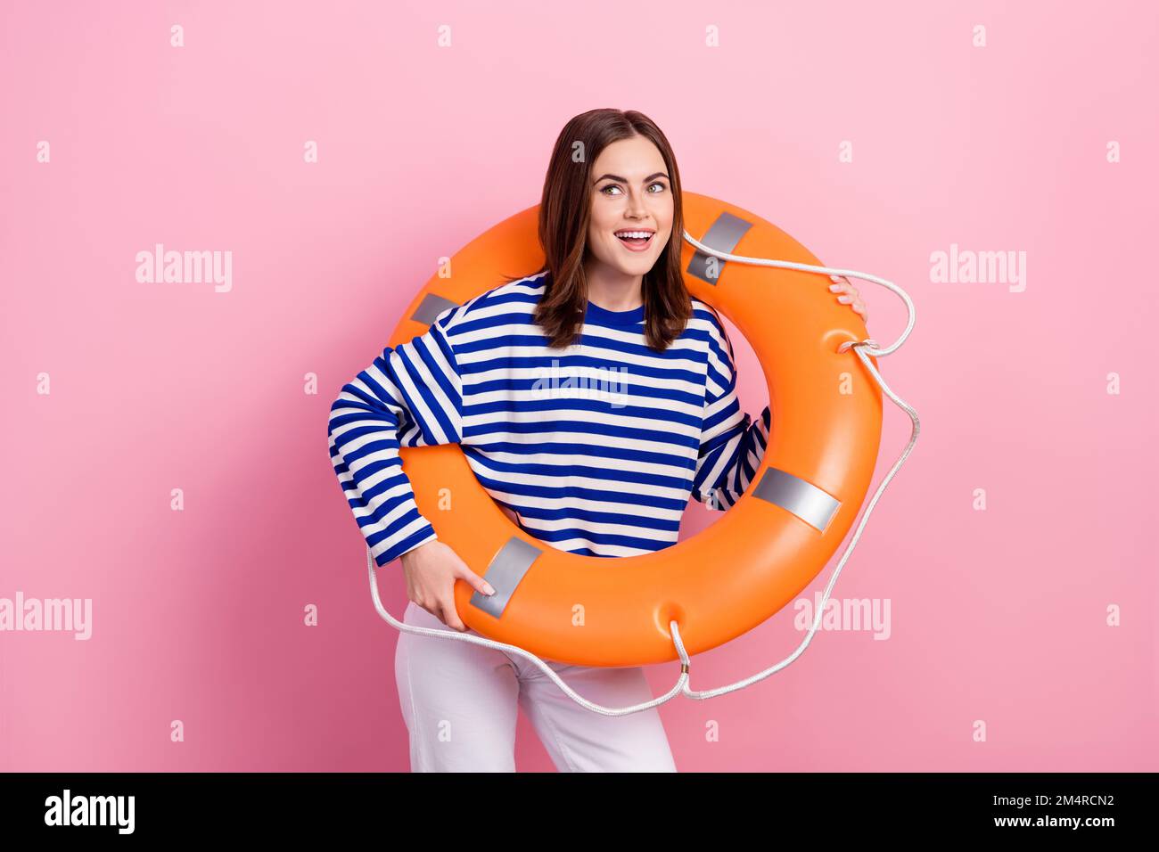 Foto von charmanter positiver Lady Hold aufblasbarer Sicherheitsring sieht interessant aus leerer Raum isoliert auf rosa Hintergrund Stockfoto