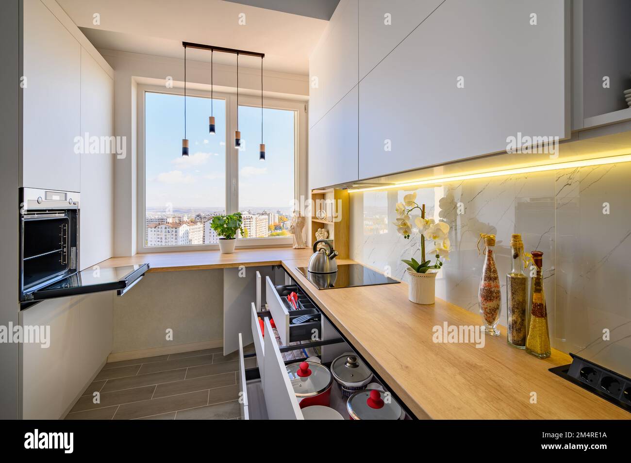 Eine elegante, weiße Küche mit ausgezogenen Schubladen Stockfoto