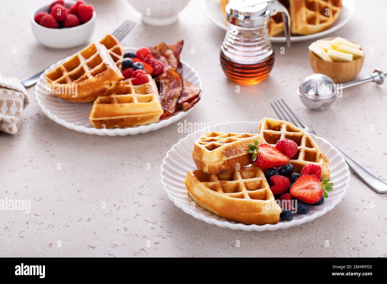 Frühstückstisch mit Waffeln, Beeren und Speck Stockfoto