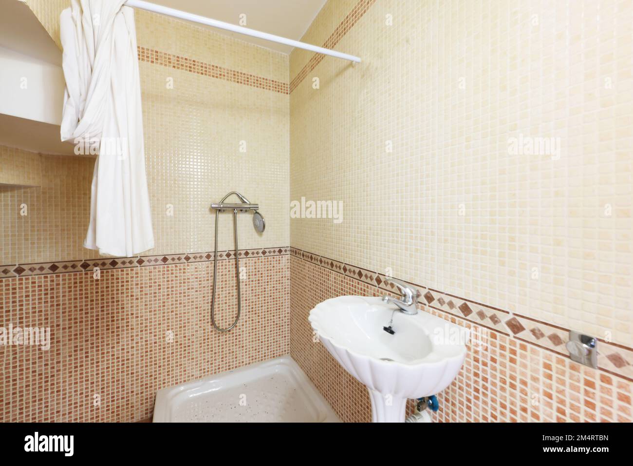 Toilette mit Muschelwaschbecken und Duschkabine mit Vorhang Stockfoto