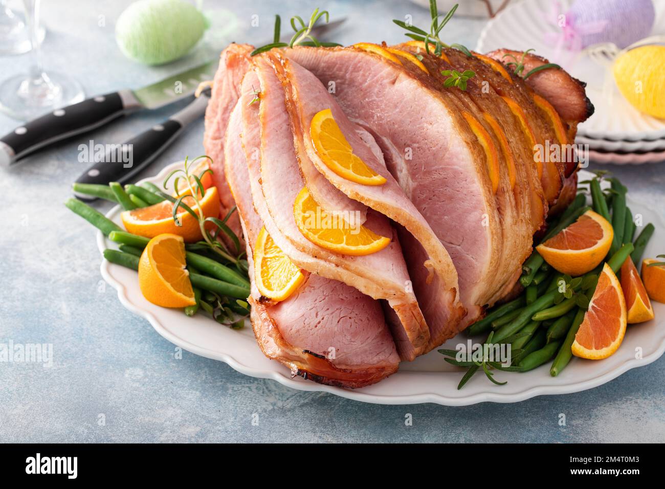 Osterschinken gefüllt mit Orangenscheiben und Kräutern, glasierter Schinken in Spiralscheiben Stockfoto