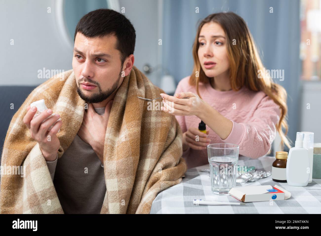 Kranker Mann, der zu Hause mit seiner Frau sitzt Stockfoto Kranker Mann, der zu Hause mit seiner Frau sitzt Stockfoto