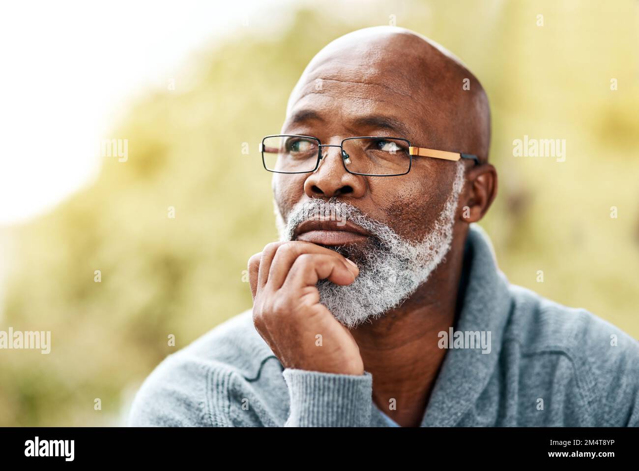 Ich denke viel, wenn ich draußen bin... ein älterer Mann, der aufmerksam aussah, während er draußen saß. Stockfoto