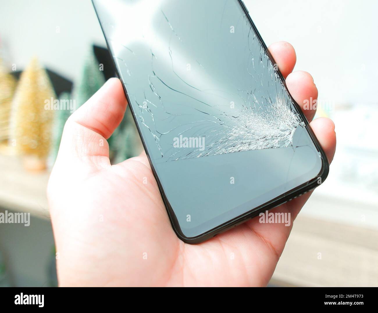 Smartphone mit gerissenem Bildschirm in der Hand, Objekt isoliert Stockfoto