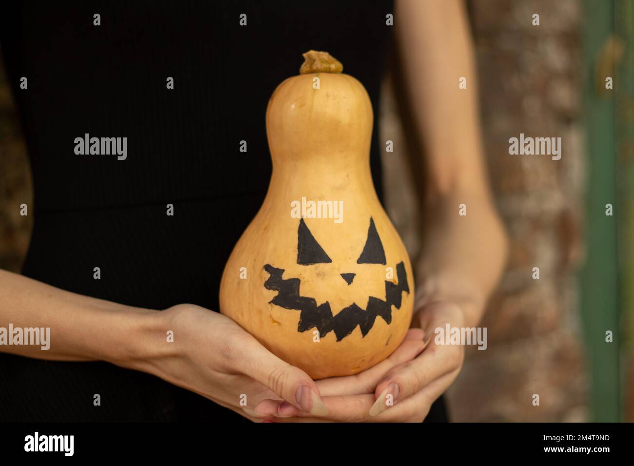 Kürbis in den Händen eines Mädchens, gemalt für halloween, halloween-Feiertag in der ukraine Stockfoto
