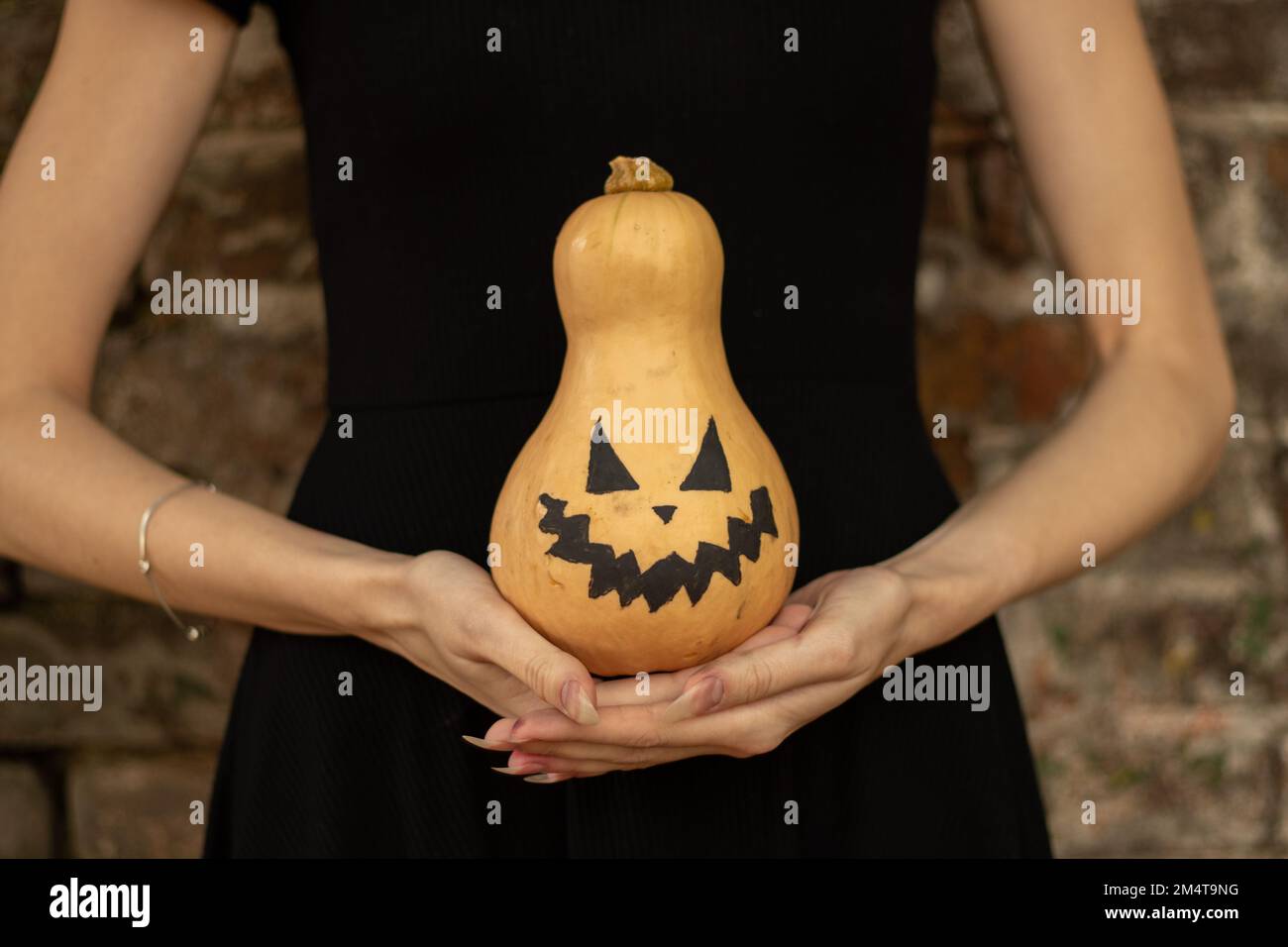 Kürbis in den Händen eines Mädchens, gemalt für halloween, halloween-Feiertag in der ukraine Stockfoto