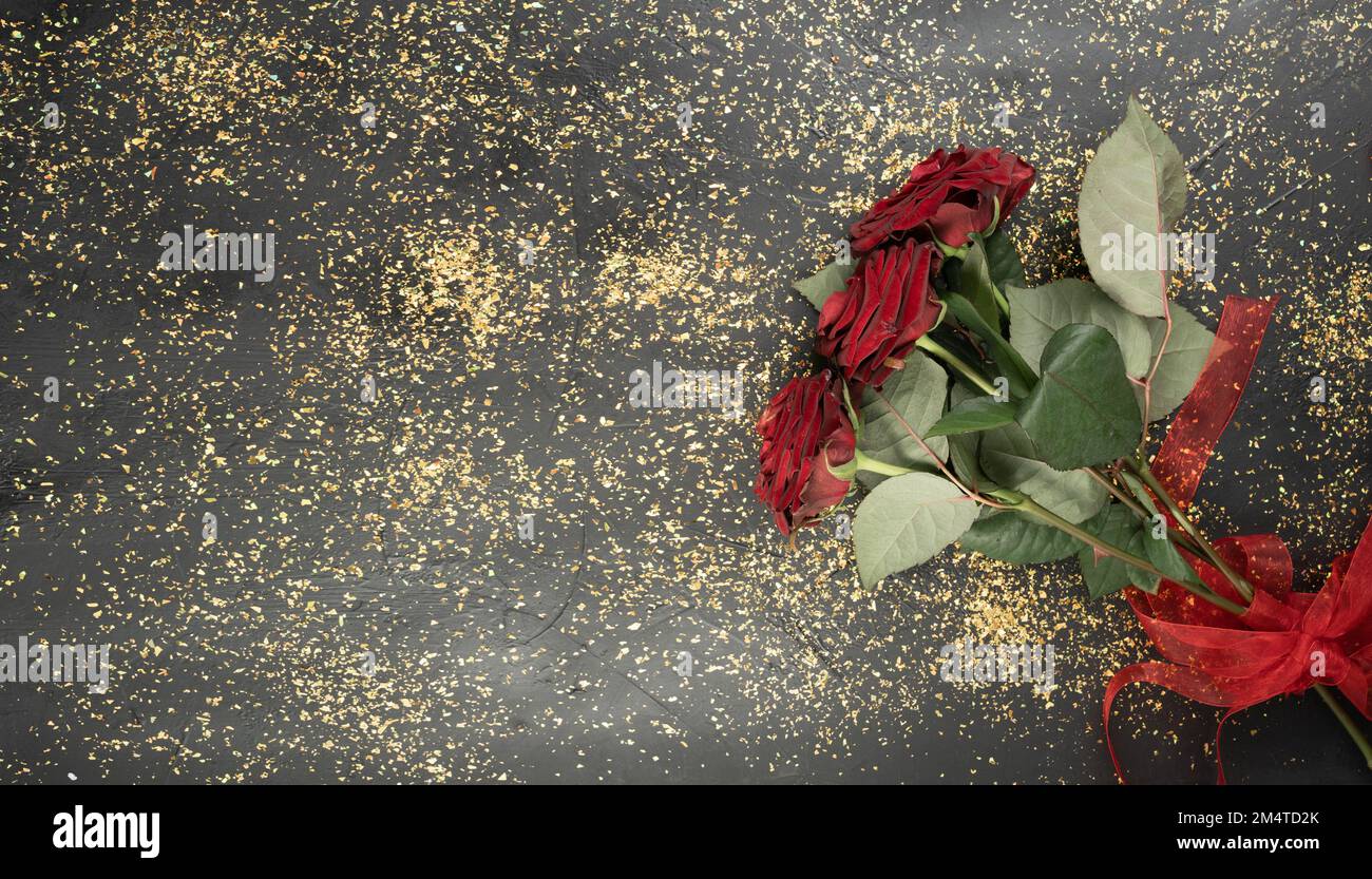 Rote Rosen auf goldglänzendem, glitzerndem Hintergrund. Valentinskarte, flach liegend. Speicherplatz kopieren. Banner Stockfoto