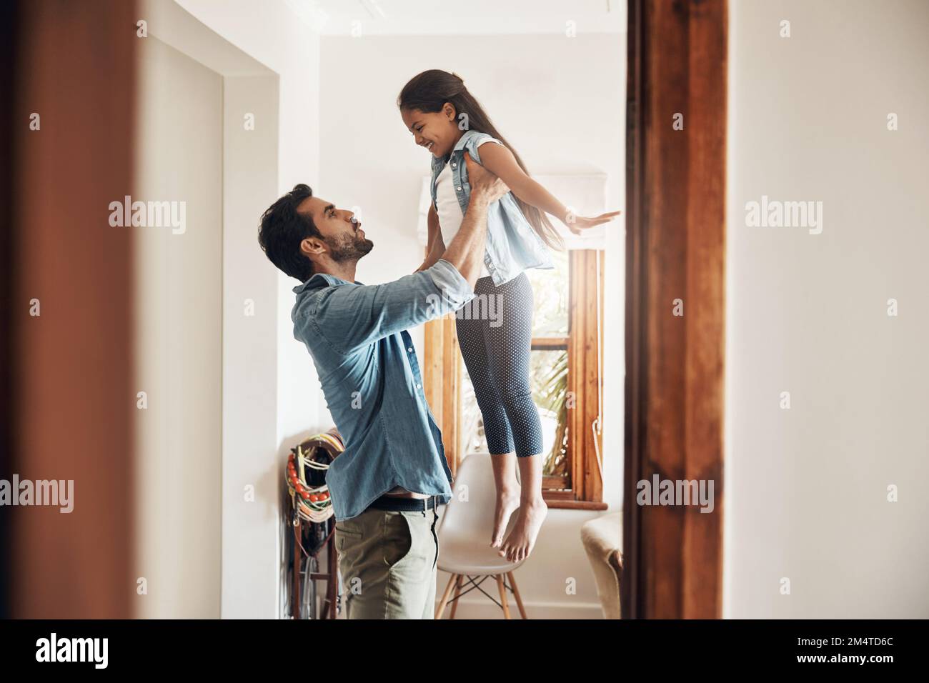 Den Spaß mit Dad aufdrehen. Ein glücklicher Vater und eine glückliche Tochter, die zu Hause zusammen spielen. Stockfoto