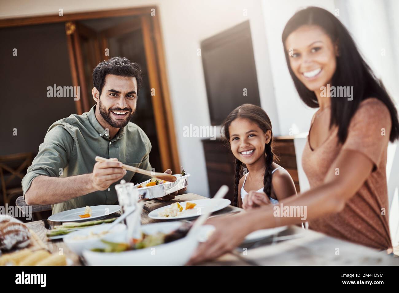 Essenszeit ist Familienzeit. Eine glückliche junge Familie, die gemeinsam im Freien speist. Stockfoto