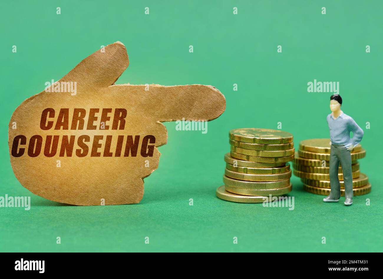 Business- und Economy-Konzept. Auf der grünen Oberfläche der Münze und der Figur eines Mannes sind sie durch ein Schild - eine Hand mit der Inschrift - AUTO gekennzeichnet Stockfoto